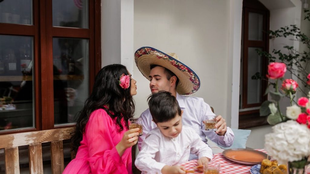 A family enjoys a celebratory moment with drinks, flowers, and a festive atmosphere.